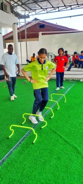 A student stepping through agility hurdles in PE class
